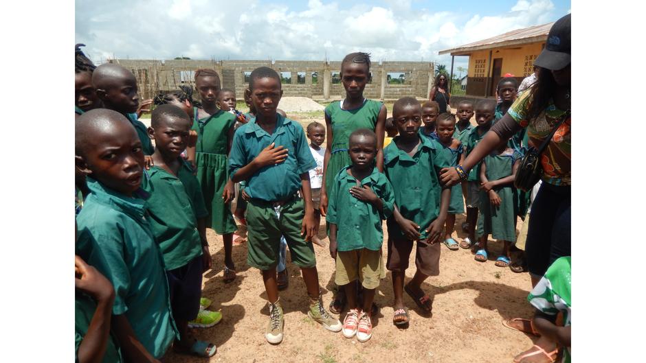 sierra leone children showing half built classrooms